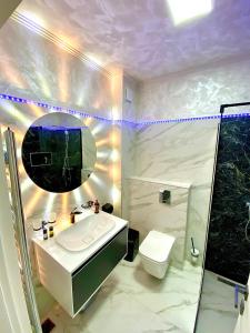 a bathroom with a sink and a toilet and a mirror at Loft side Premium Apartments in Mamaia
