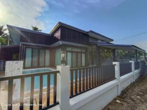 a house with a fence and a swimming pool at AWA Pool Villa in Ban Huai Yai