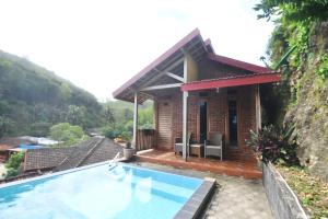 a small house with a swimming pool in front of it at Villa Kopiori in Yogyakarta