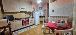 a kitchen with a table and a kitchen with a refrigerator at Casa Lory in Pescina
