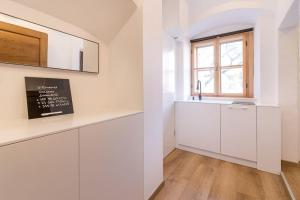 a kitchen with white cabinets and a window at Studio Arco Rustic in Zagreb