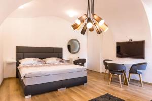 a bedroom with a bed and a table with chairs at Studio Arco Rustic in Zagreb