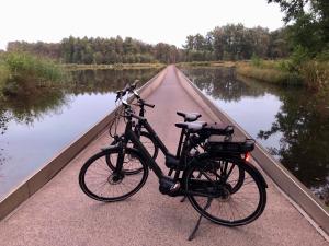 a bike parked on a bridge next to a river at Huis Vanellus in Hasselt