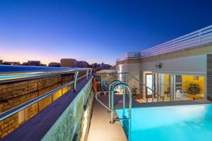 a balcony of a house with a swimming pool at C4 Retreats by Georges Boutique Living in Xagħra