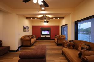 a living room with couches and a flat screen tv at Plachoos Gardens - A luxury serviced villa in Kuttikkanam, Peermede in Pīrmed