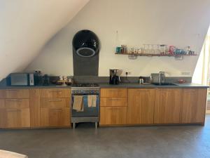 a kitchen with wooden cabinets and a stove top oven at Slaopen en Stoet in Anderen