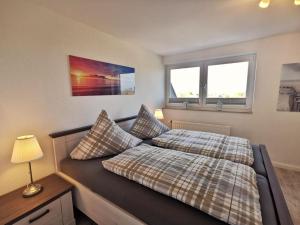 Un dormitorio con una cama y dos ventanas. en Wohnung 02, en Horumersiel