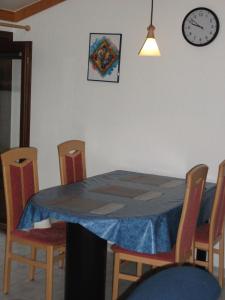 a dining room table and chairs with a clock on the wall at Ruhiges Ferienhaus im Herzen des Seebades De Haan in De Haan