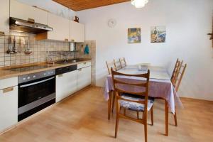 Una cocina con una mesa y sillas en una habitación. en Bungalow Renate, en Dornum