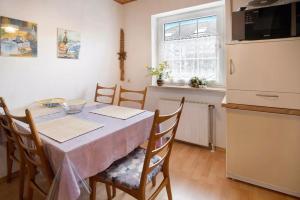 Una cocina con una mesa con sillas y un refrigerador. en Bungalow Renate, en Dornum 15 fotos más
