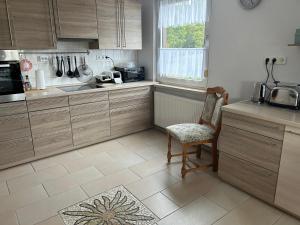 Rehburg-LoccumFerienwohnung Winzenburg Natur nah und ruhig gelegene Ferienwohnung nah am Steinhuder Meer und Dinopark Münchehagen的厨房配有木制橱柜、椅子和水槽 更多34张照片