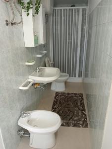 a bathroom with a white toilet and a sink at Casa wendy in Bolsena +13 photos
