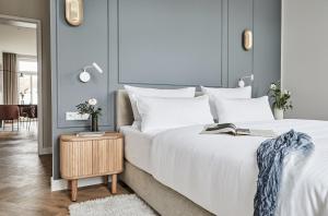 a bedroom with a large white bed and a table at Villa Esperance - Suite Céleste mit Balkon, Dampfbad Whg 10 in Binz