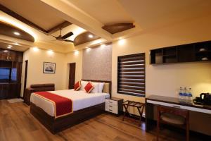 a hotel room with a bed and a desk at Plachoos Gardens - A luxury serviced villa in Kuttikkanam, Peermede in Pīrmed