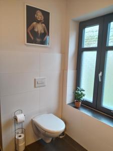 a bathroom with a toilet and a picture of a woman at Wohnung Nr 1 in Bargischow +5 photos