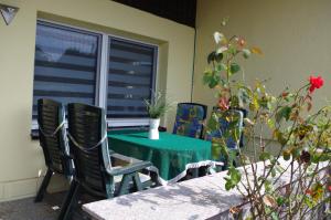 a green table and chairs on a patio at Ferienhaus Ostseebodden in Sundhagen +12 photos