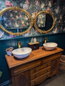 a bathroom with two sinks on a wooden dresser with mirrors at The Duke Hotel in Hilmarton +237 photos