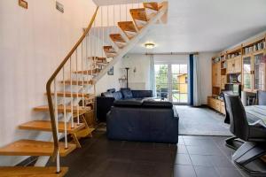a living room with a spiral staircase and a couch at Lizzy in Dornum