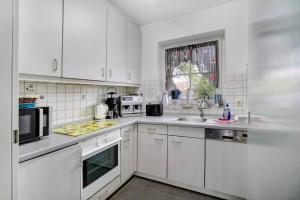 a white kitchen with white appliances and a window at Lizzy in Dornum +15 photos