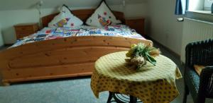 a bedroom with a wooden bed with a table at Küstenglück Nessmersiel in Neßmersiel +7 photos
