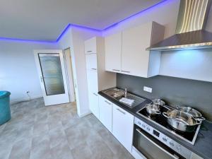 ヴァンガーラントにあるWohnung 21の白いキャビネットとコンロ付きオーブンを備えたキッチン