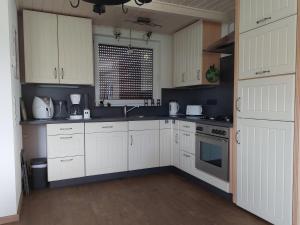 une cuisine avec des armoires blanches et un évier dans l'établissement Ferienhaus Landlust - b69076, à Meschede