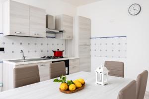 a kitchen with a table with a bowl of fruit on it at Ciuri ciuri in Santa Flavia