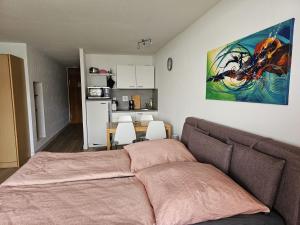 a bedroom with a bed and a table and a kitchen at Gipfelfreund 2 in Sankt Englmar