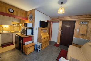 a room with a kitchen and a living room at Appartement idéal famille - pied des pistes in Les Déserts