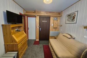 a small room with a bed and a flat screen tv at Appartement idéal famille - pied des pistes in Les Déserts +13 photos