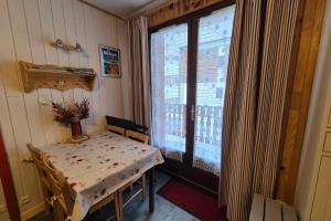 a room with a table and a window at Appartement idéal famille - pied des pistes in Les Déserts