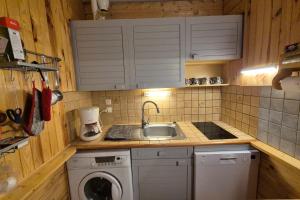 a small kitchen with a sink and a washing machine at Appartement idéal famille - pied des pistes in Les Déserts