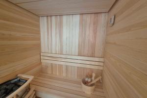 Una pequeña sauna de madera con dos muñecas en una cesta. en Découvrez ce magnifique appartement au pied des pistes à La Féclaz, en La Féclaz