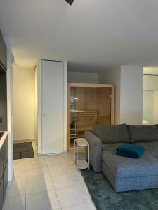 Una sala de estar con un sofá y una cocina. en Découvrez ce magnifique appartement au pied des pistes à La Féclaz, en La Féclaz 24 fotos más