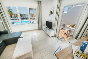 Televízia a/alebo spoločenská miestnosť v ubytovaní Bahia Calma Beach