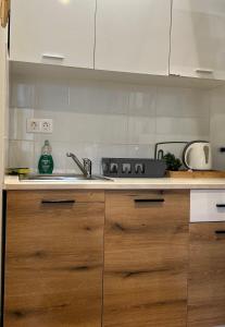 Una cocina con gabinetes de madera y un fregadero. en Κομψό Πέτρινο Διαμέρισμα για Ζευγάρια - Apt IV, en La Canea