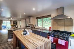 a large kitchen with a red stove top oven at Stanton, woodland lodge with hot tub for 14 in Oakamoor