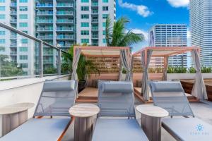 a balcony with chairs and tables and a view of the city at Beautiful Apartment with gym and amazing Pool in Miami