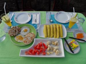 een tafel met borden ontbijtproducten erop bij Sigiri Lake Paradise in Sigiriya