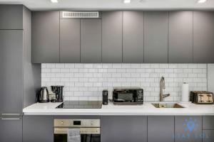 a kitchen with gray cabinets and a counter top at Beautiful Apartment with gym and amazing Pool in Miami