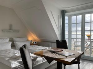 a bedroom with a table and a bed and a window at Huus Lüttenblick Whg Strandblick in Wyk auf Föhr