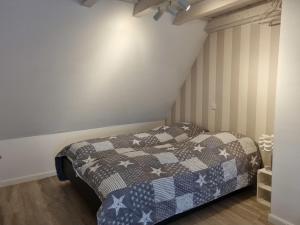 a bedroom with a bed with a blue and white quilt at Reetglück in Wrixum