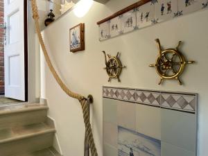 a staircase with nautical items on the wall at Huus Lüttenblick Whg Kajüte in Südstrand