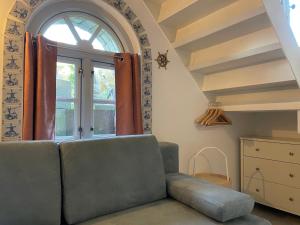 a living room with a couch and a window at Huus Lüttenblick Whg Kajüte in Südstrand