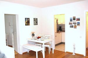 a white dining room with a white table and chairs at Hanseat II App112 Ostseeglanz in Grömnitzerhagen