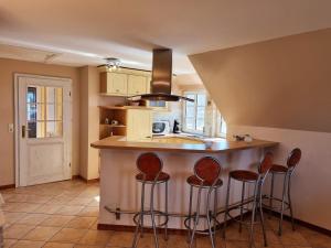 una cocina con isla con taburetes de bar en Landtraum, en Oevenum