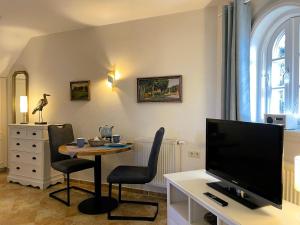 a living room with a tv and a table with chairs at Huus Lüttenblick Whg Halligenblick in Wyk auf Föhr