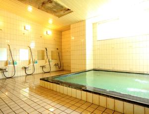 a large swimming pool in a bathroom with showers at Hakuba Tsugaike Sunrise Tanne in Otari