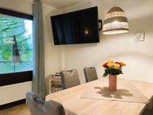 a dining room table with a vase of flowers on it at Fischerhuus Whg 3 in Wyk auf Föhr