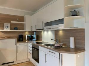 a kitchen with white cabinets and a sink at Fischerhuus Whg 3 in Wyk auf Föhr